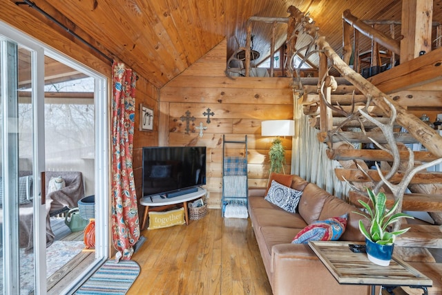 living area with vaulted ceiling, hardwood / wood-style floors, wood walls, and wooden ceiling