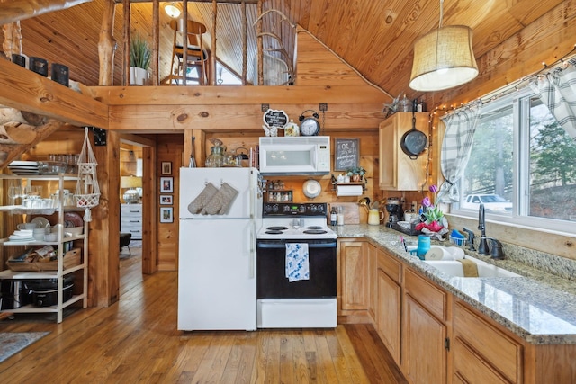 kitchen featuring white appliances, light wood finished floors, wooden walls, wooden ceiling, and a sink