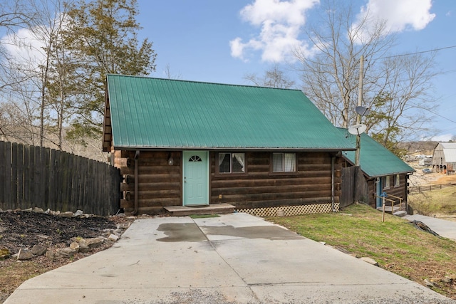 log cabin with entry steps, fence, metal roof, log siding, and driveway