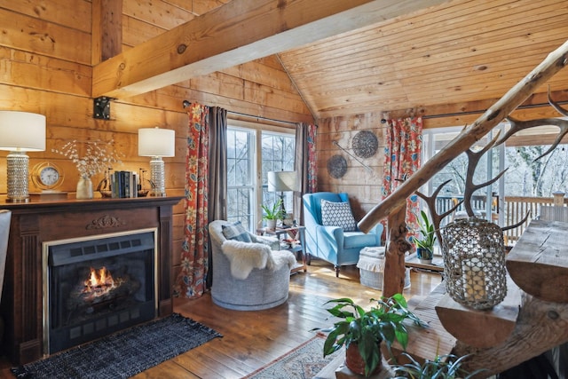 living room with wooden walls, wood ceiling, vaulted ceiling, a lit fireplace, and hardwood / wood-style floors