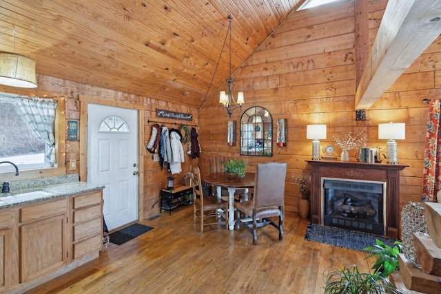 dining space featuring wooden ceiling, vaulted ceiling, wooden walls, and light wood finished floors