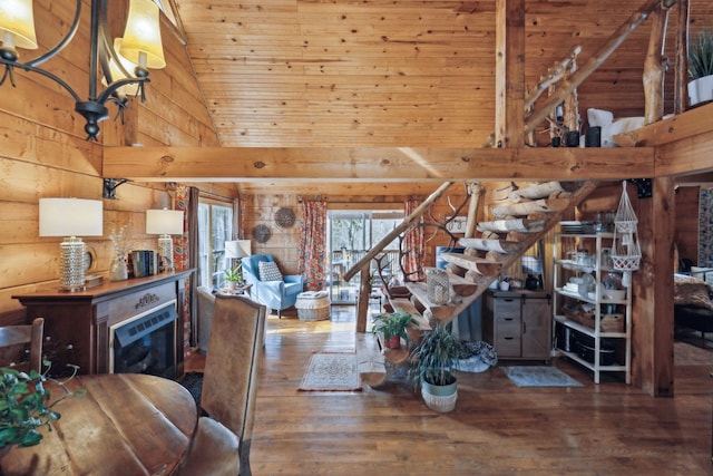 dining space with wooden walls, a high ceiling, stairway, and wood finished floors