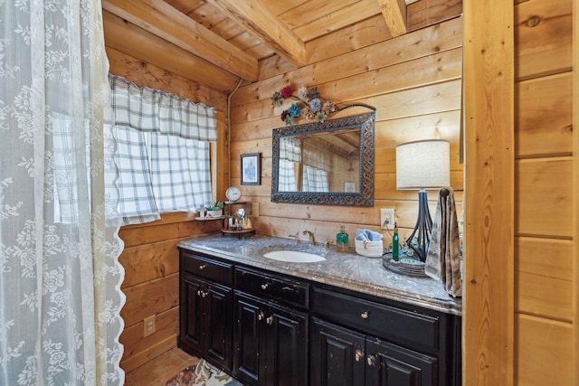 bathroom featuring wood walls, wood ceiling, beamed ceiling, and vanity