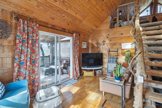 living area with lofted ceiling, wooden ceiling, wood-type flooring, and wooden walls