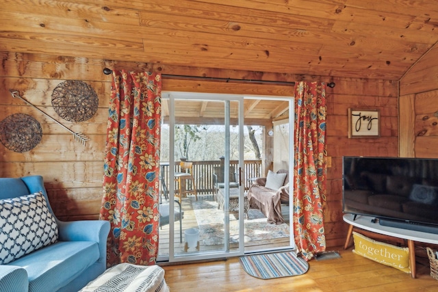 living area with wood walls, wood ceiling, vaulted ceiling, and hardwood / wood-style floors