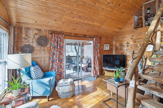 living area featuring vaulted ceiling, wood walls, wood finished floors, and wood ceiling