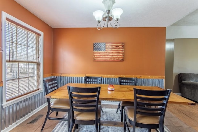 dining space featuring tile patterned flooring, visible vents, and an inviting chandelier