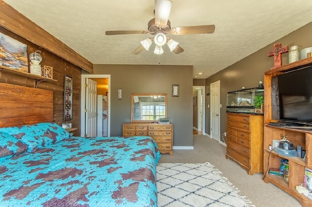 carpeted bedroom featuring baseboards, a ceiling fan, and a textured ceiling