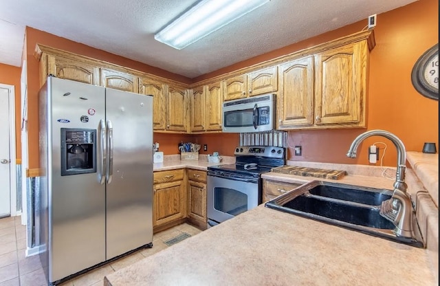 kitchen with light tile patterned floors, light countertops, visible vents, appliances with stainless steel finishes, and a sink