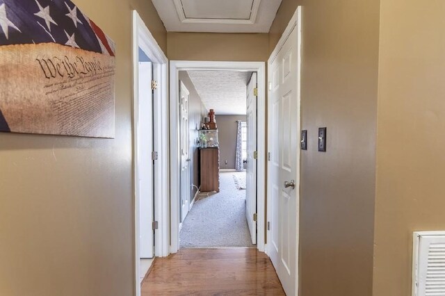 corridor with baseboards and wood finished floors