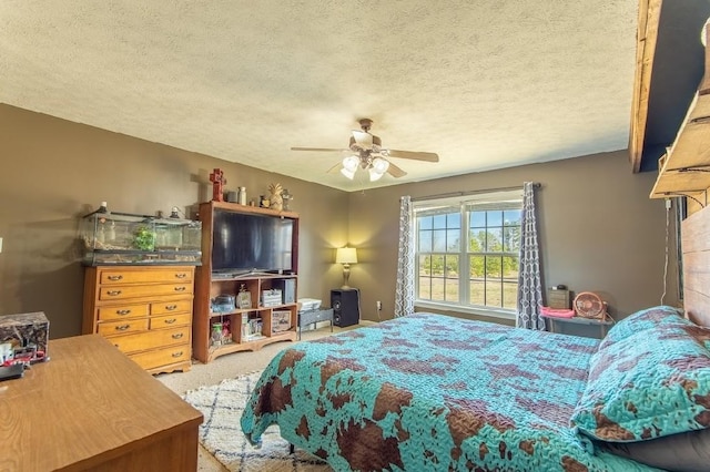 bedroom featuring carpet floors, a textured ceiling, and a ceiling fan