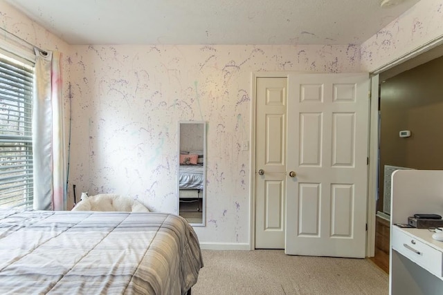 bedroom with wallpapered walls, baseboards, and light colored carpet