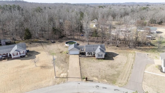 birds eye view of property featuring a forest view