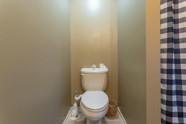 full bathroom featuring toilet, baseboards, a shower with shower curtain, and tile patterned floors