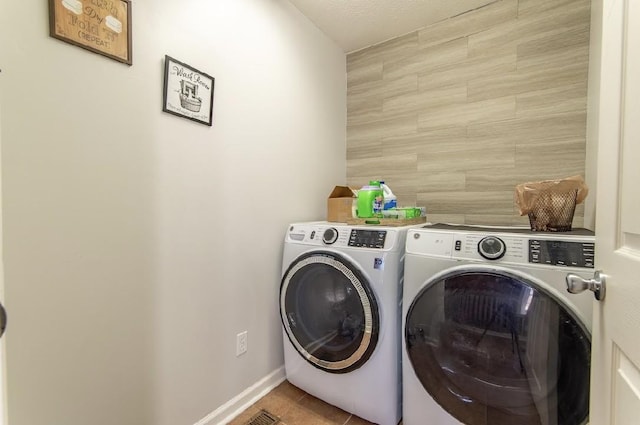 laundry room with laundry area, washer and clothes dryer, tile patterned flooring, and baseboards