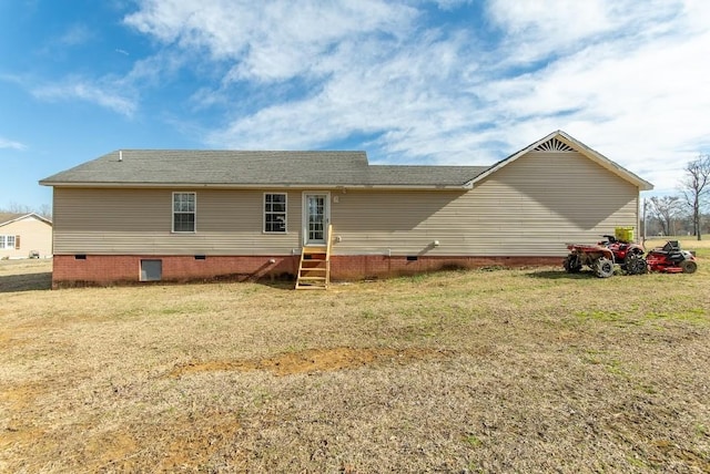 back of property with entry steps, crawl space, and a yard