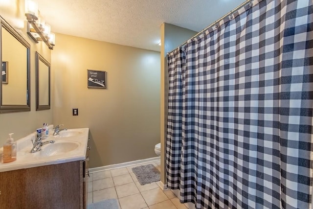 full bath with double vanity, a textured ceiling, a sink, and tile patterned floors