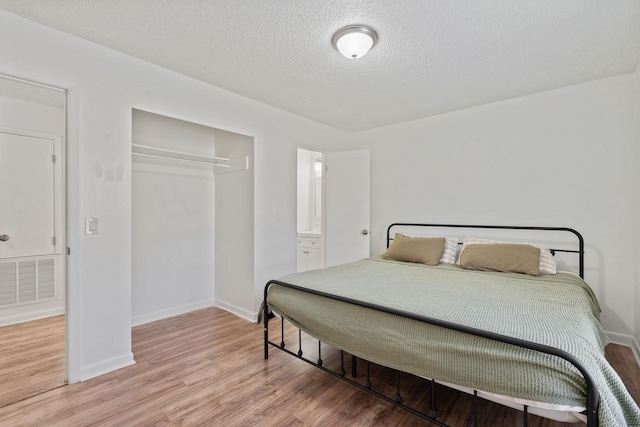 bedroom featuring light wood-style flooring, a closet, visible vents, and baseboards