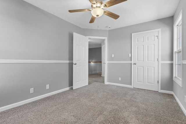 unfurnished bedroom featuring carpet flooring, ceiling fan, and baseboards