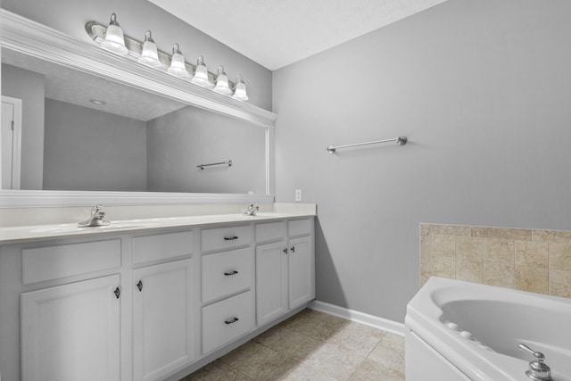 full bath featuring double vanity, baseboards, a sink, and a bath