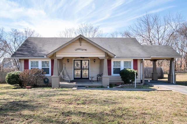 view of front of house featuring driveway, covered porch, french doors, a front lawn, and a carport