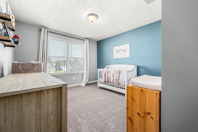 bedroom with a textured ceiling, carpet, and baseboards