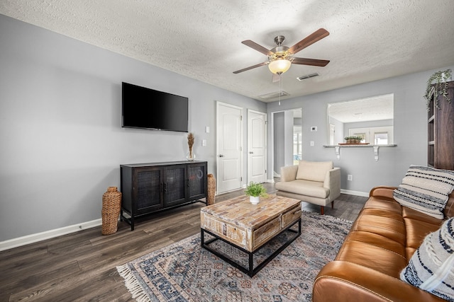 living room featuring baseboards, visible vents, ceiling fan, wood finished floors, and a textured ceiling