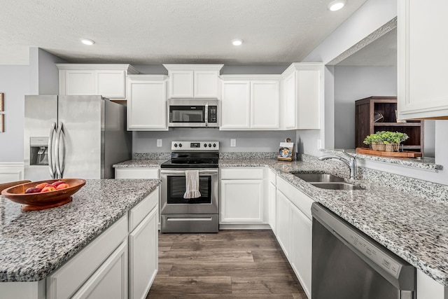 kitchen with dark wood-style floors, white cabinetry, appliances with stainless steel finishes, and a sink