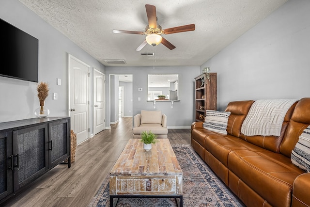 living room featuring a textured ceiling, a ceiling fan, and wood finished floors