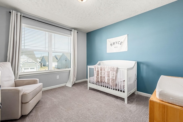 bedroom with a nursery area, carpet, and baseboards