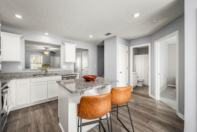 kitchen featuring a sink, white cabinets, range, a center island, and dishwasher