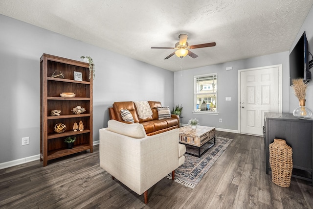 living room with a textured ceiling, dark wood finished floors, a ceiling fan, and baseboards