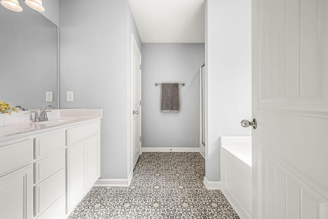 full bathroom featuring a shower stall, vanity, baseboards, and a bath