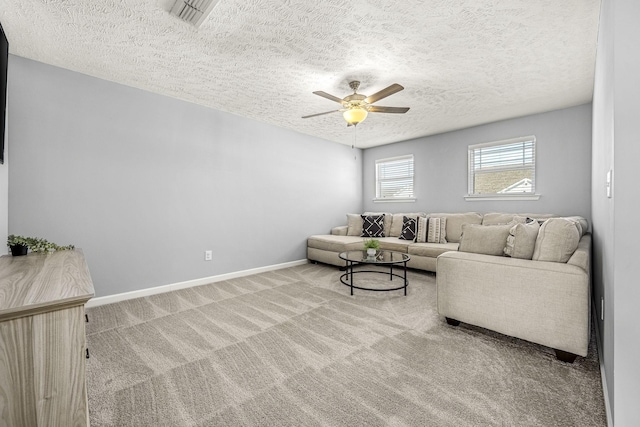 carpeted living area featuring ceiling fan, a textured ceiling, visible vents, and baseboards