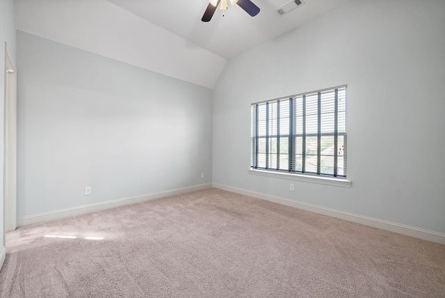 spare room with baseboards, visible vents, a ceiling fan, vaulted ceiling, and carpet floors