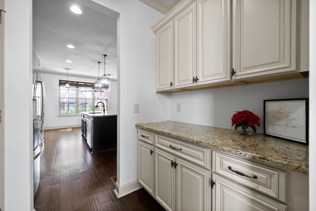 kitchen with recessed lighting, a sink, dark wood-style floors, stainless steel fridge, and decorative light fixtures