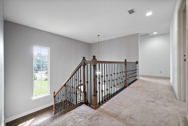 hall with recessed lighting, an upstairs landing, visible vents, and baseboards