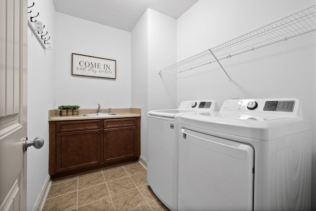 laundry room featuring cabinet space, baseboards, separate washer and dryer, a sink, and light tile patterned flooring