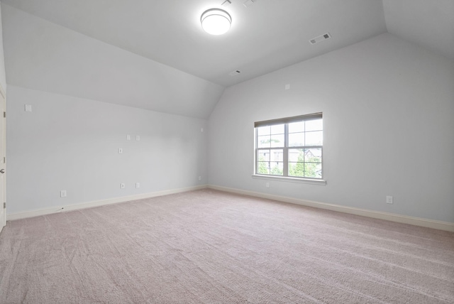 additional living space featuring vaulted ceiling, carpet flooring, visible vents, and baseboards