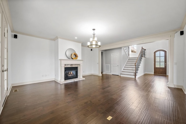 unfurnished living room featuring visible vents, dark wood-style floors, ornamental molding, stairs, and a brick fireplace