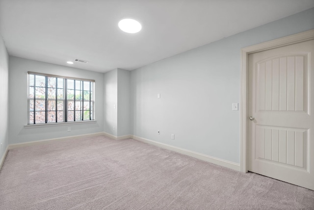 carpeted spare room with visible vents and baseboards