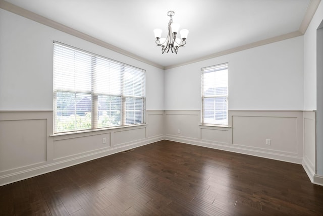 empty room featuring a chandelier, ornamental molding, wood finished floors, and visible vents