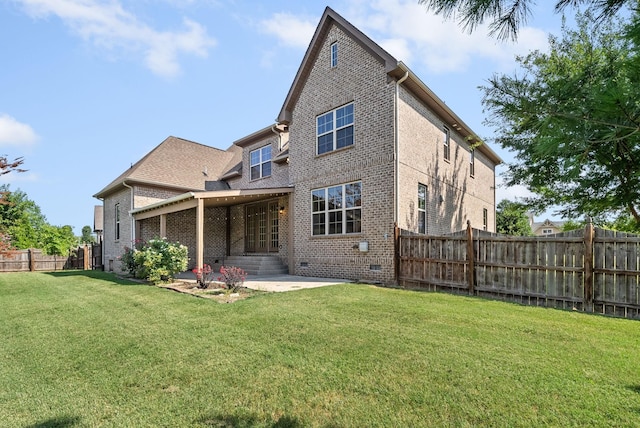 back of house with crawl space, fence, a lawn, and brick siding