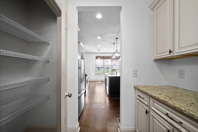 interior space with dark wood-style floors, recessed lighting, a sink, baseboards, and stainless steel refrigerator