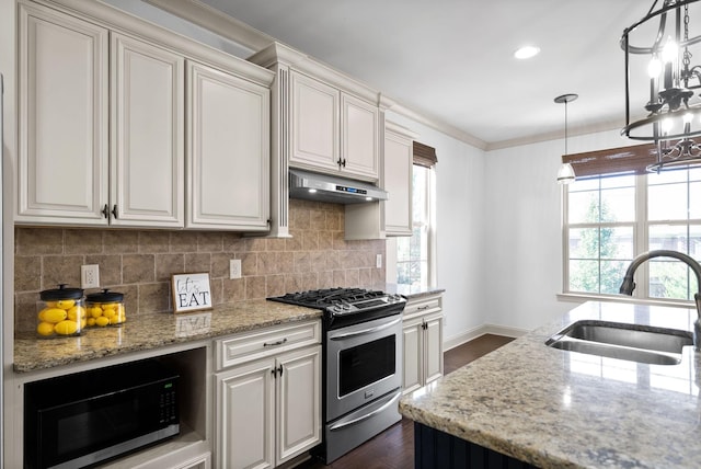 kitchen featuring stainless steel range with gas cooktop, backsplash, a sink, light stone countertops, and under cabinet range hood