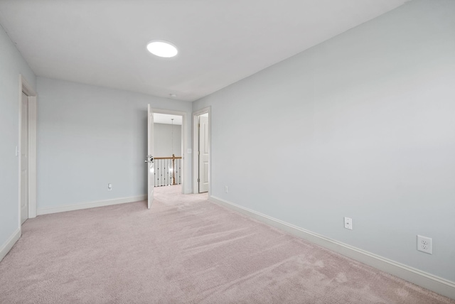 unfurnished bedroom with light carpet and baseboards