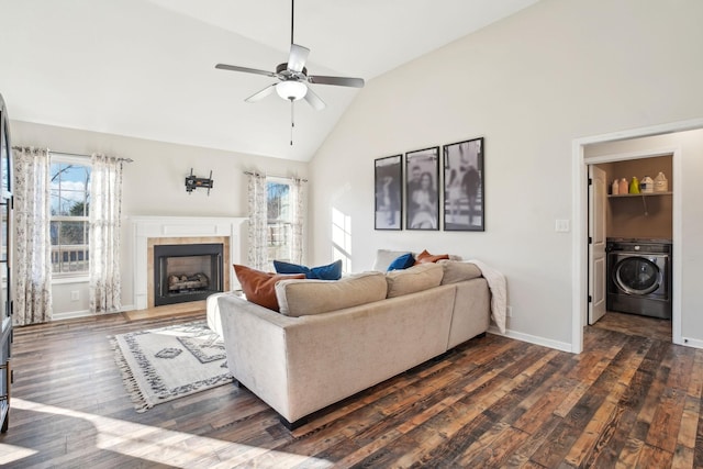 living room with washer / dryer, a healthy amount of sunlight, and dark wood-style floors