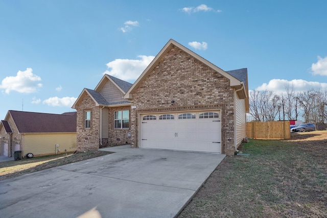 view of front facade with a garage, driveway, fence, and brick siding