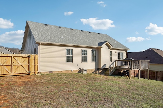 back of property with a deck, a shingled roof, fence, crawl space, and a gate