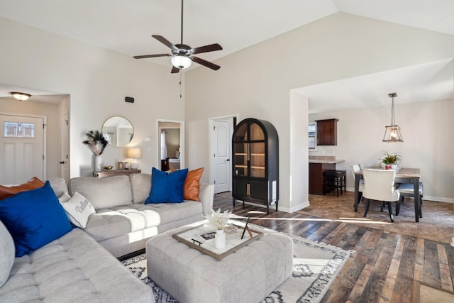 living room with baseboards, high vaulted ceiling, ceiling fan, and wood finished floors